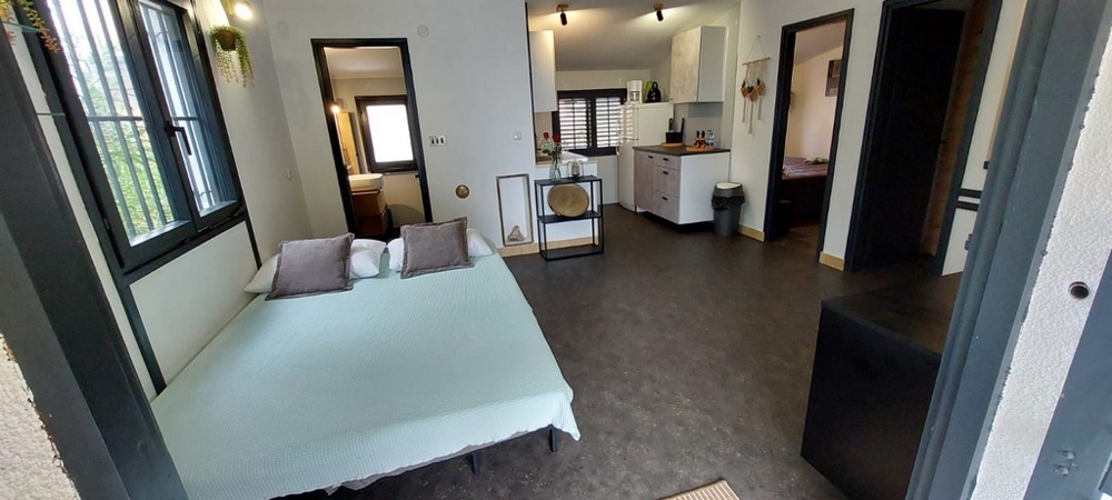 Letto in uno spazio aperto con cucina e bagno sul retro