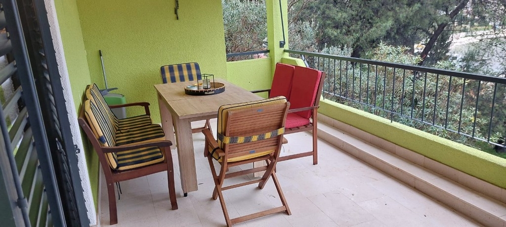 Loggia con tavolo in legno e sedie pieghevoli rosse