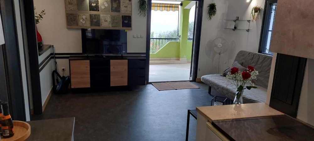 Soggiorno con parete TV e porta aperta sul balcone