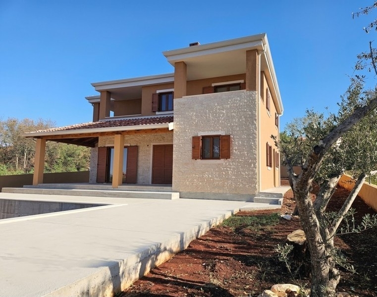 Casa con torre in pietra naturale e pergola in legno allo stato grezzo