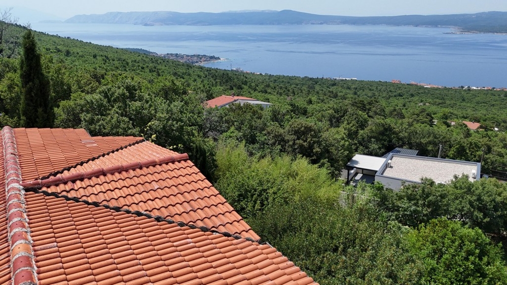 Tetto in tegole con vista sul bosco, sulla baia e sulle montagne