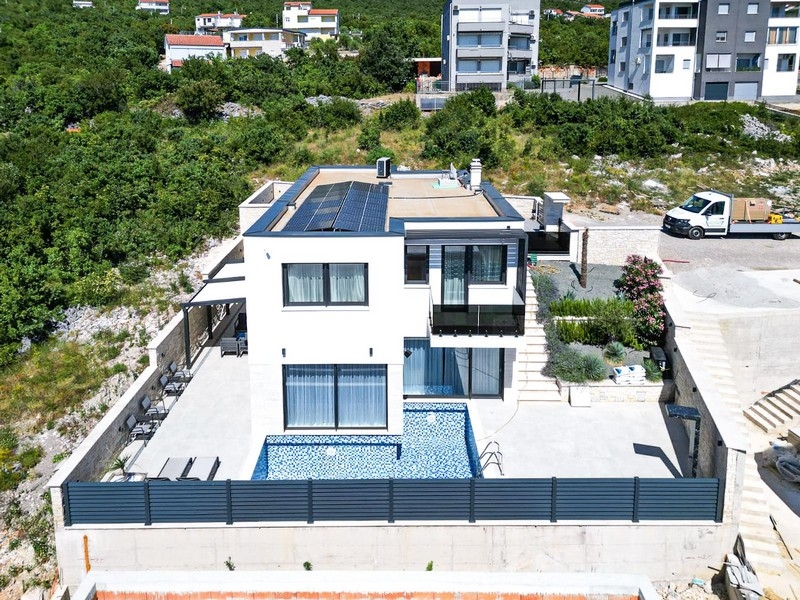 Veduta aerea della villa con pannelli solari e piscina blu