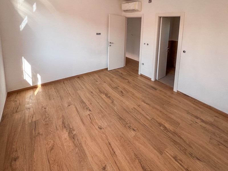 Camera da letto luminosa con pavimento in legno