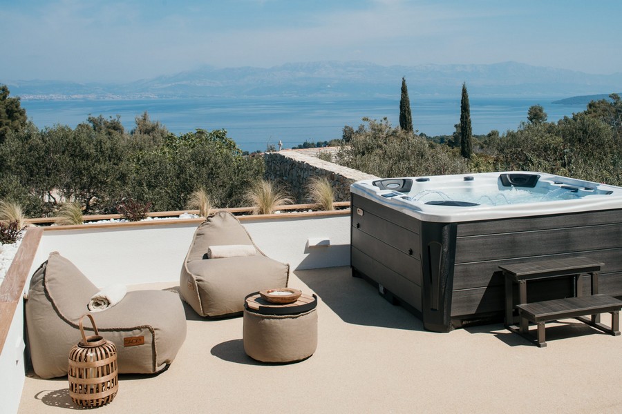 Terrazza sul tetto con vasca idromassaggio e pouf, vista sul mare