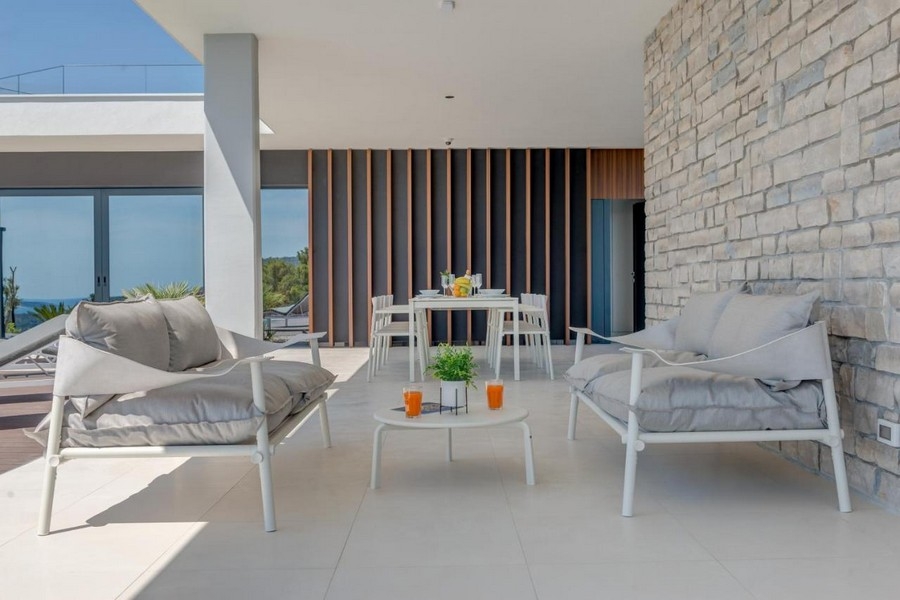 Zona seduta sulla terrazza con parete in pietra naturale