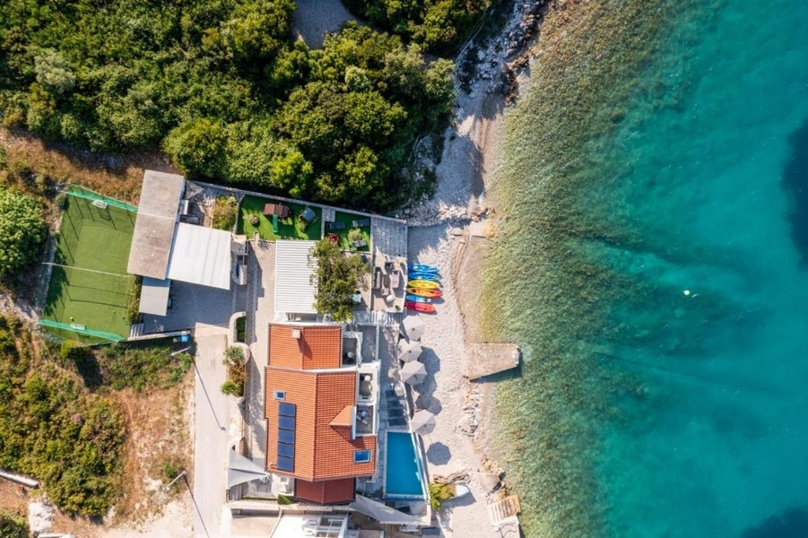 Veduta aerea della casa con piscina e kayak sulla spiaggia di ghiaia