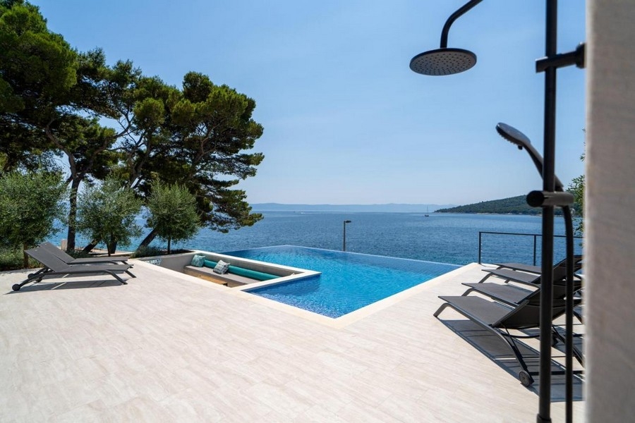 Piscina a sfioro con doccia esterna e vista mare