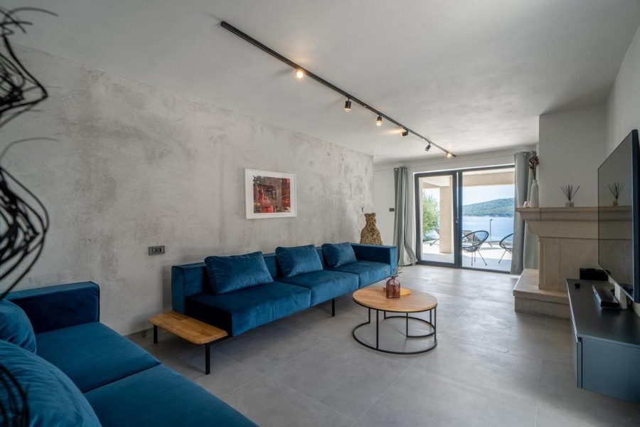 Soggiorno con divani blu e vista mare