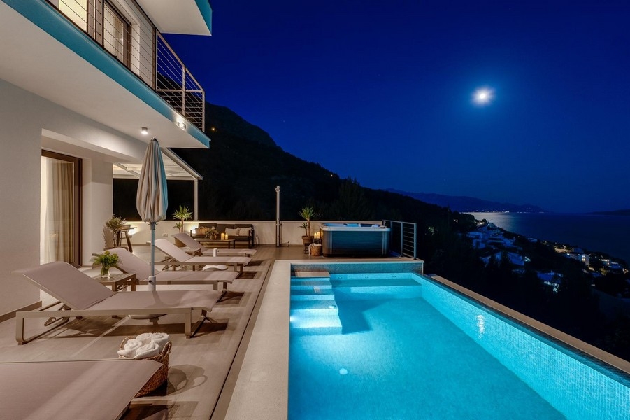 Villa con piscina di notte e vista sul mare