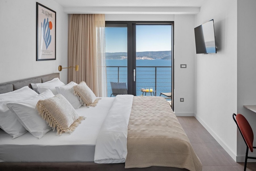 Camera da letto con letto matrimoniale, balcone e vista mare