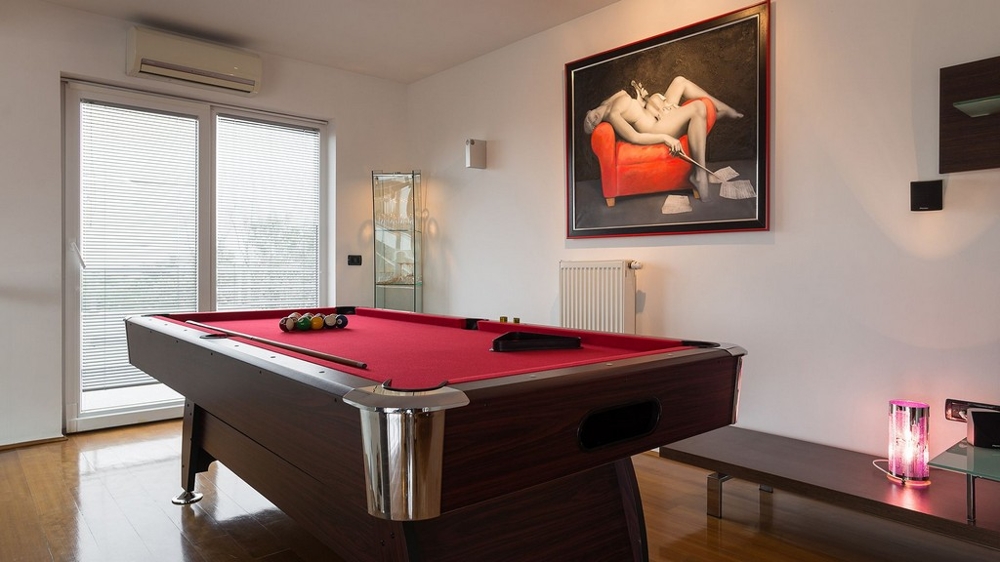 Sala giochi con tavolo da biliardo e arredamento moderno