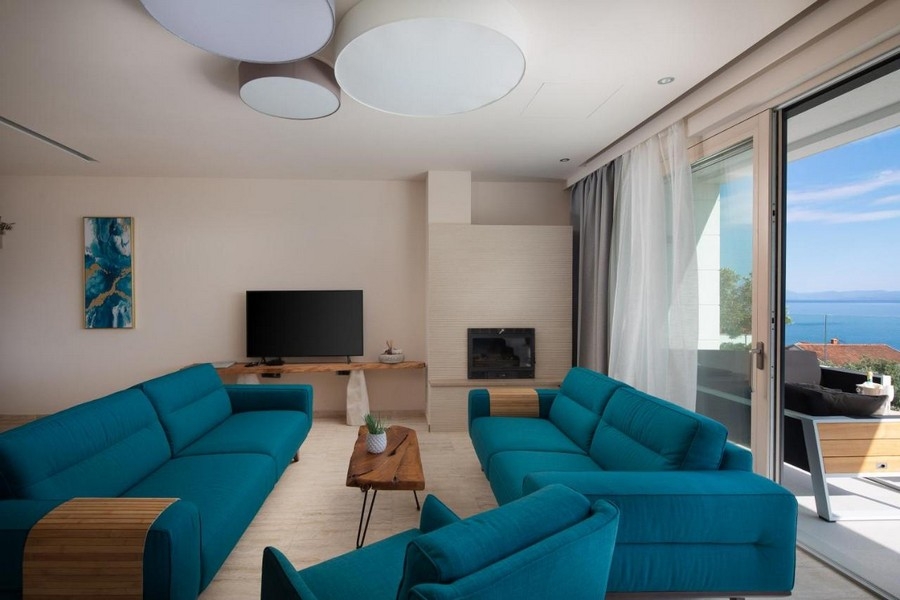 Soggiorno moderno con divani blu e vista mare