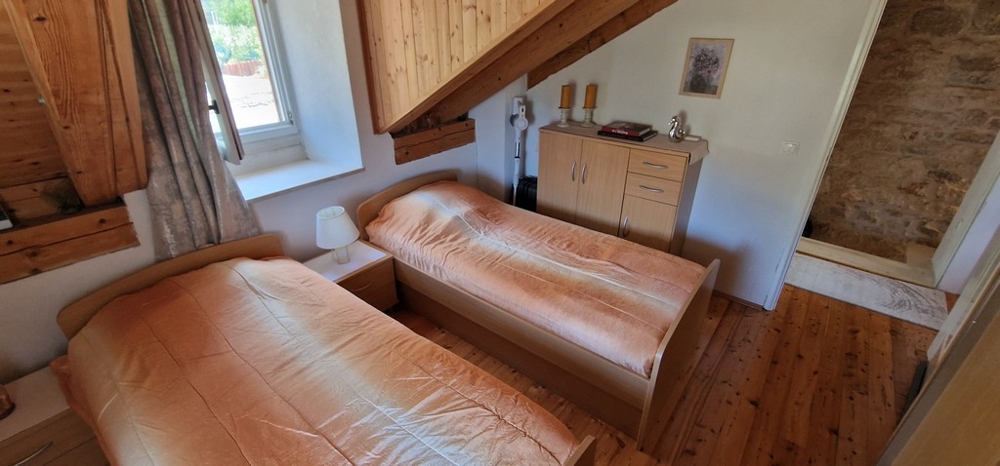 Camera da letto con due letti singoli e pavimento in legno