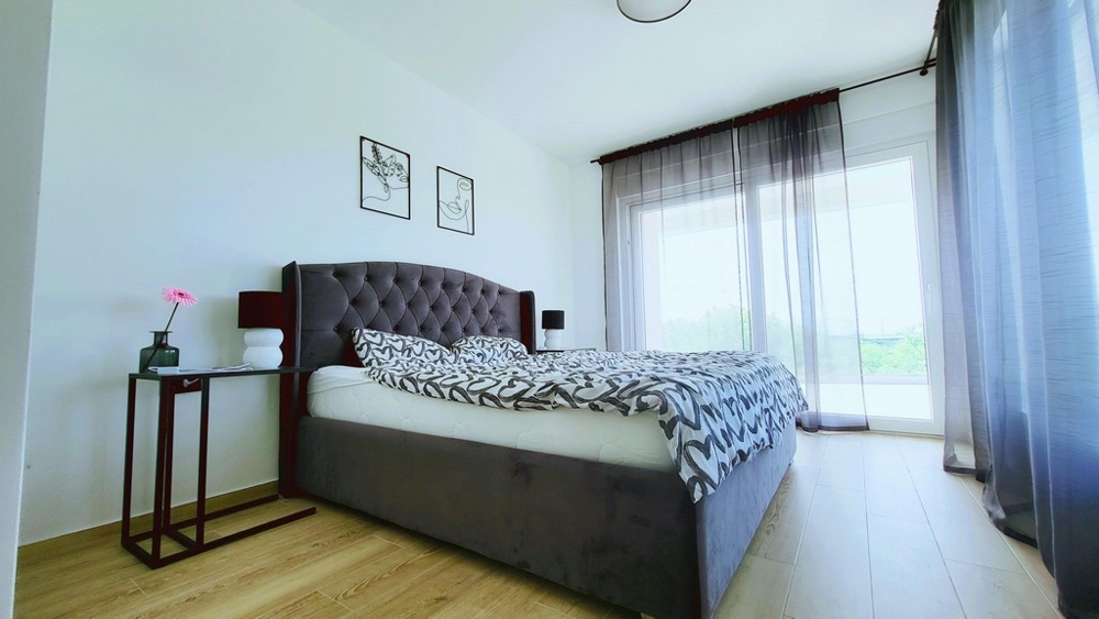 Camera da letto luminosa con letto matrimoniale e accesso al balcone