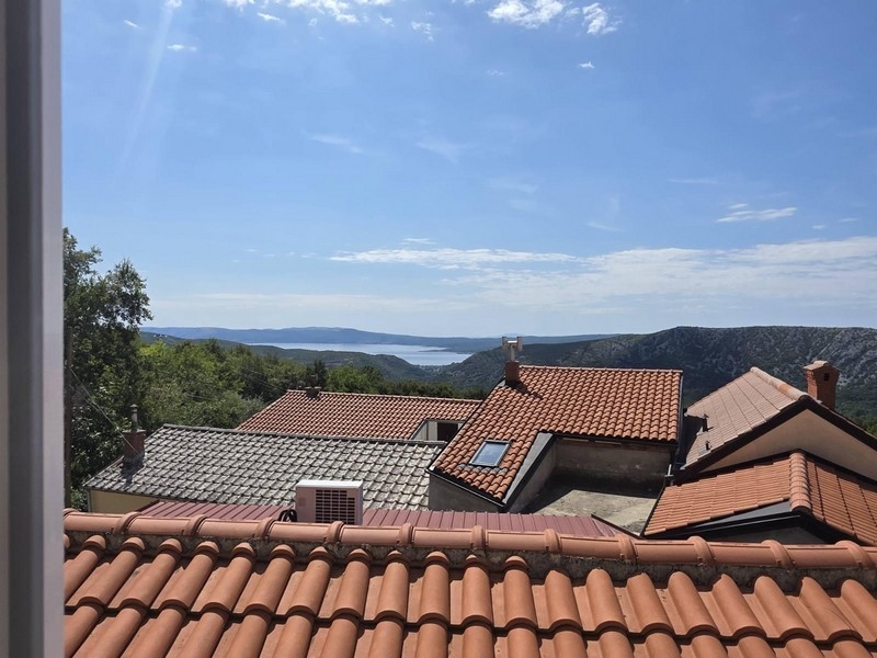 Vista sui tetti di tegole del paese e sulla baia