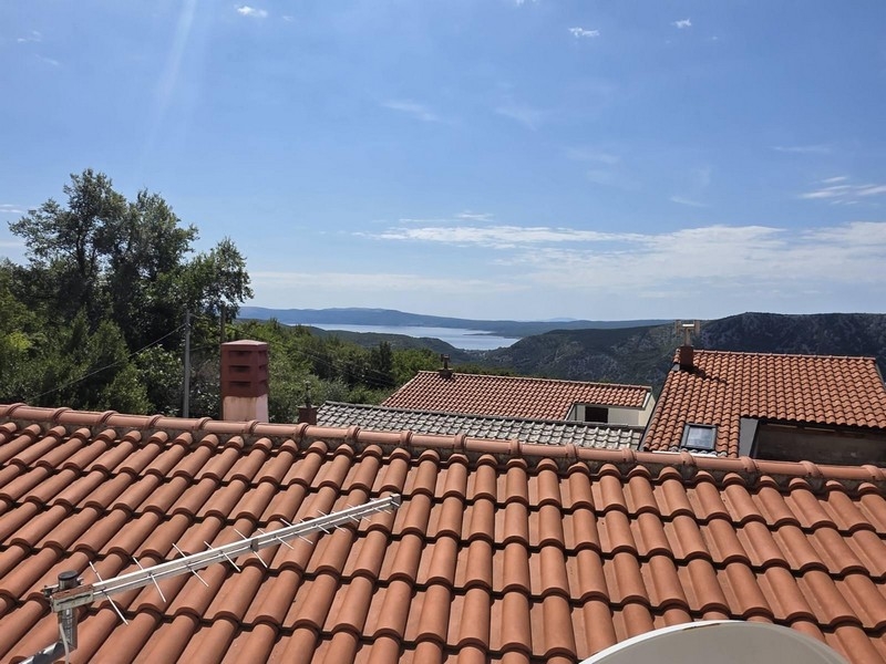 Vista dalla terrazza sul tetto sopra i tetti di tegole fino al mare