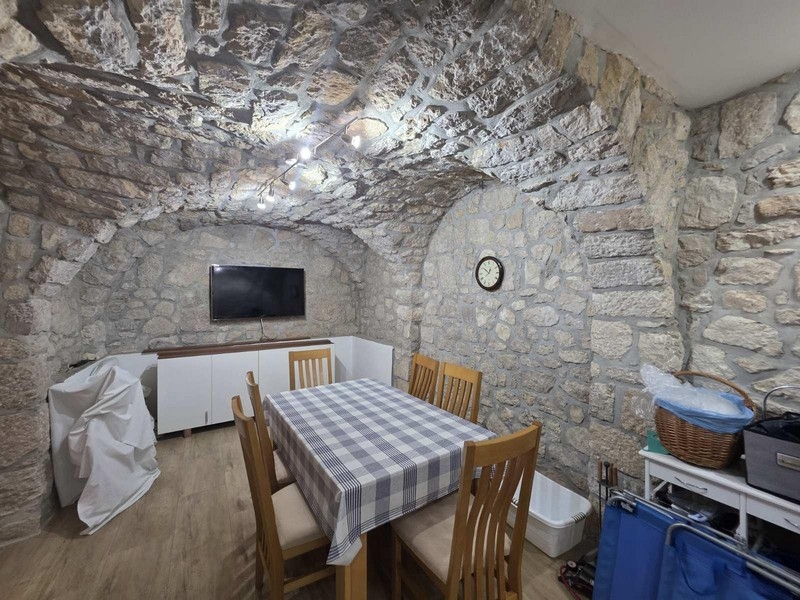 Konoba in pietra muratura con tavolo in legno e sedie