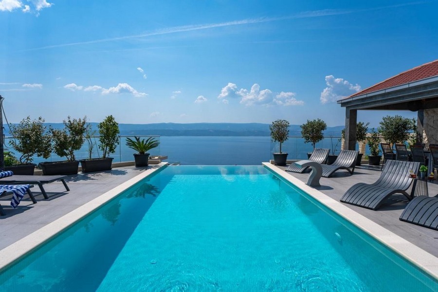 Piscina a sfioro con vista mare panoramica e lettini prendisole