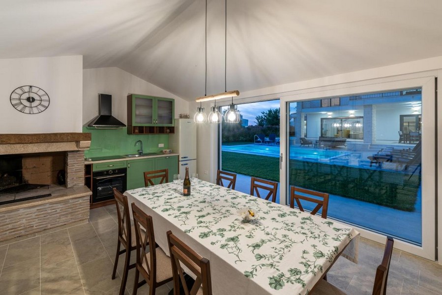 Zona pranzo nell'edificio annesso con camino e accesso al giardino