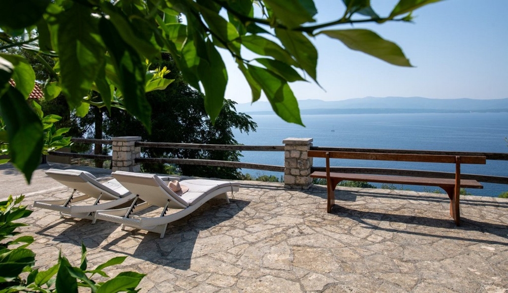 Terrazza in pietra con lettini prendisole e vista mare panoramica