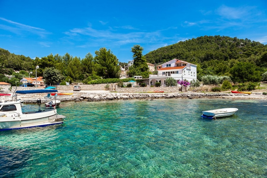 Vista della casa H3677 direttamente sul mare con barche nella baia