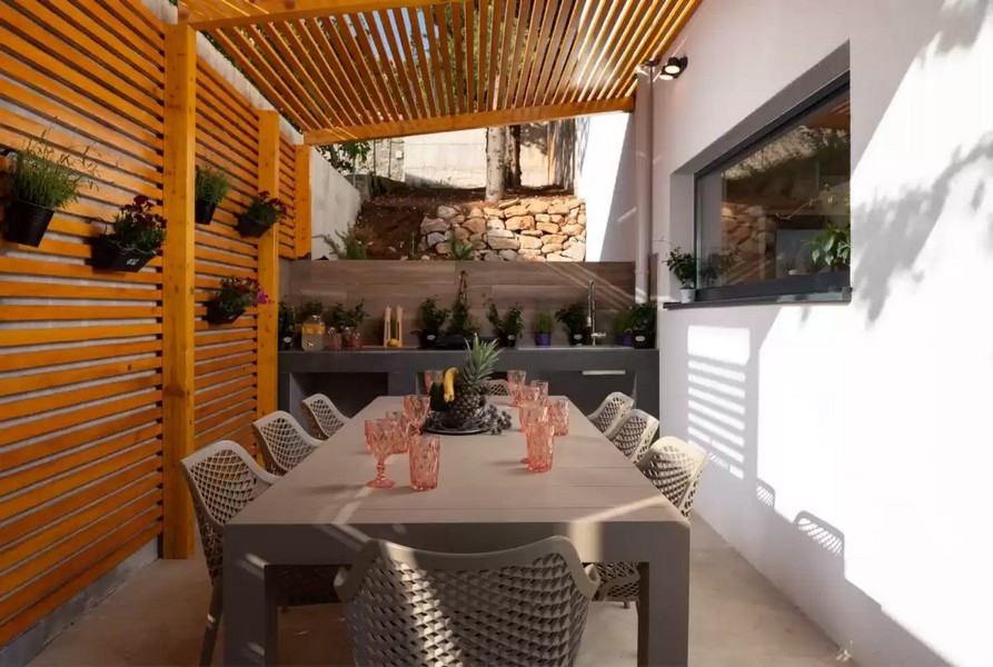 Cucina estiva coperta con tavolo da pranzo e pergola