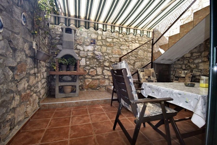 Terrazza coperta con barbecue in pietra e zona relax