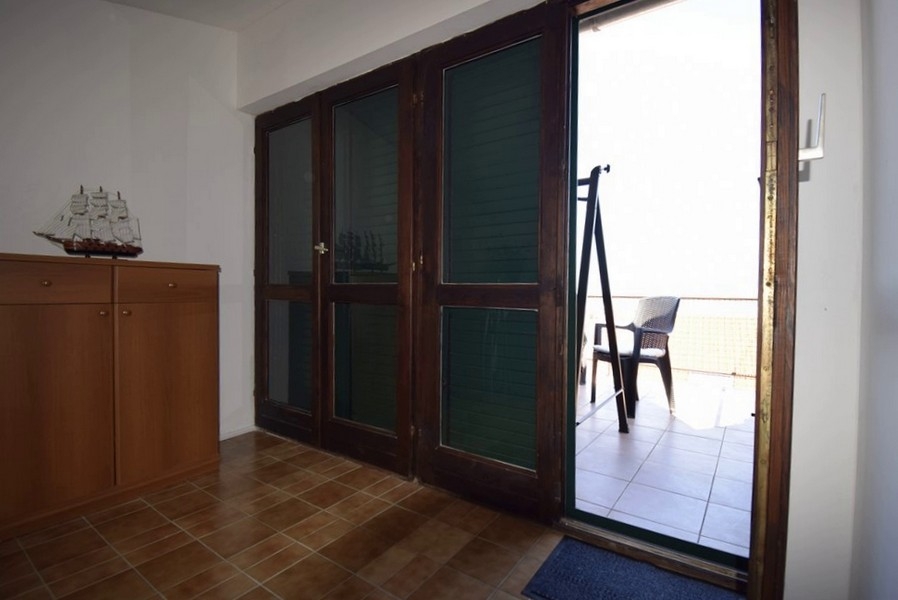 Accesso alla terrazza con vista mare attraverso grandi porte a vetri
