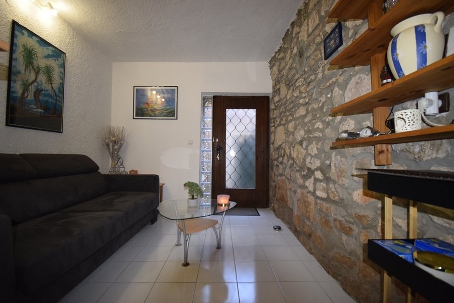 Soggiorno con parete in pietra e divano