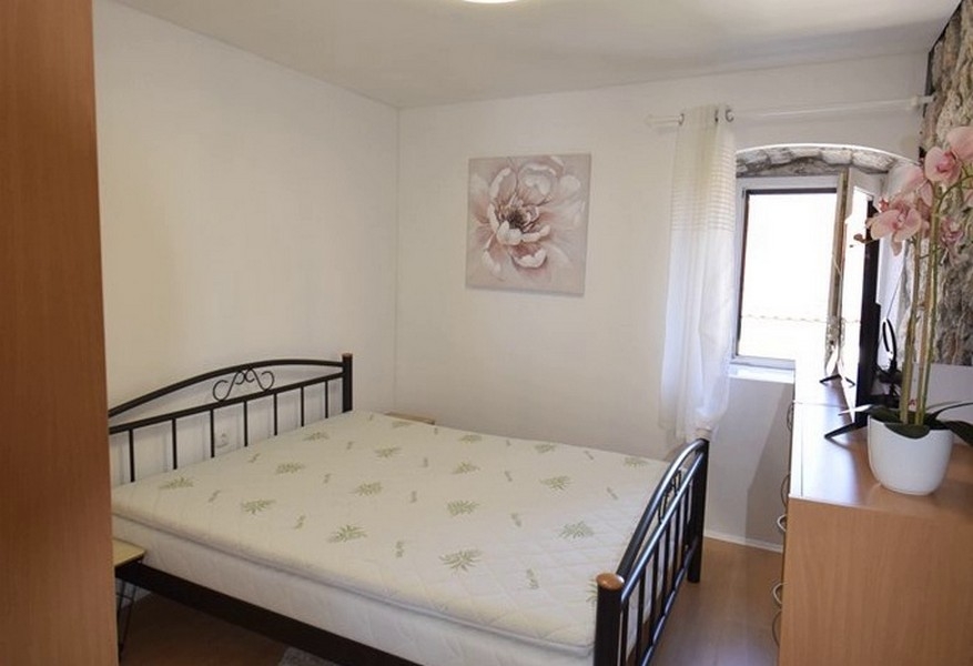 Camera da letto con letto matrimoniale e parete in pietra