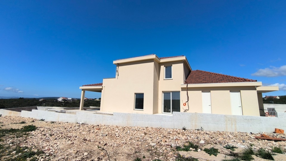 Lato della casa con porta della terrazza e muro al grezzo