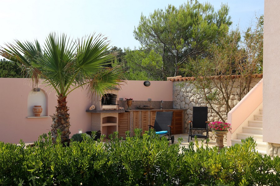 Area esterna con cucina estiva, zona barbecue e palme
