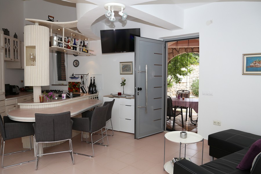 Soggiorno luminoso con cucina moderna e accesso alla terrazza