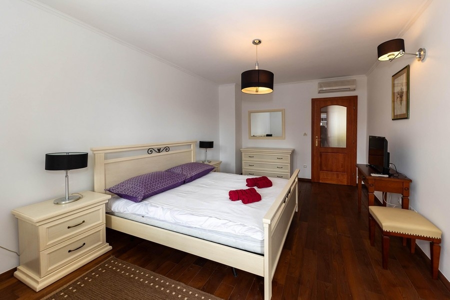 Camera da letto luminosa con letto matrimoniale e mobili in legno