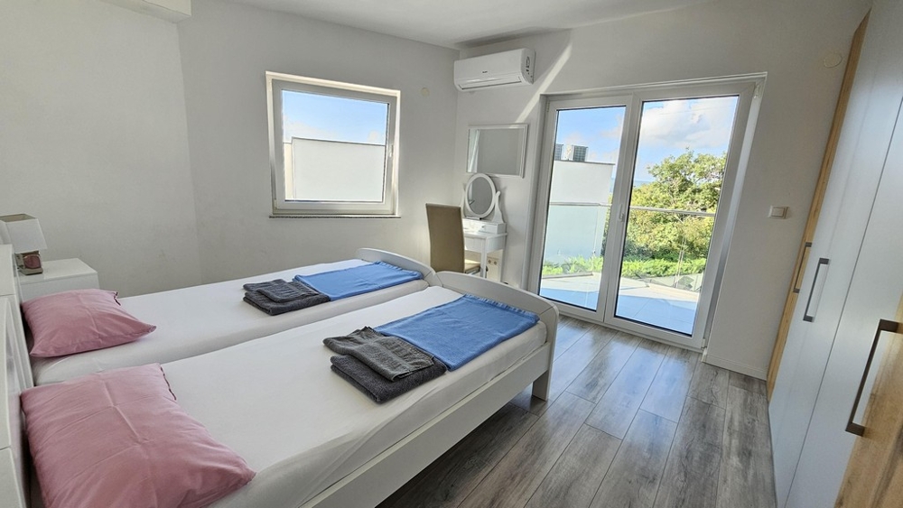 Camera da letto con due letti e accesso al balcone