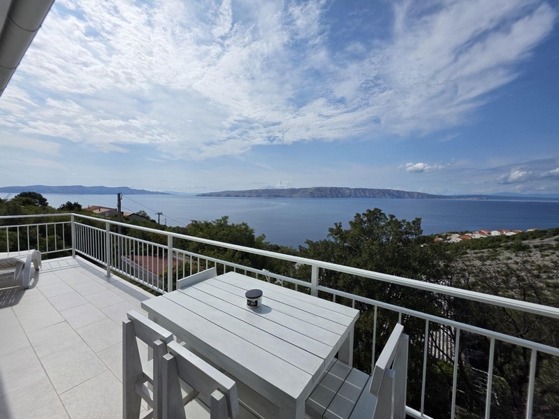 Balcone con tavolo e vista sulla baia fino all'isola