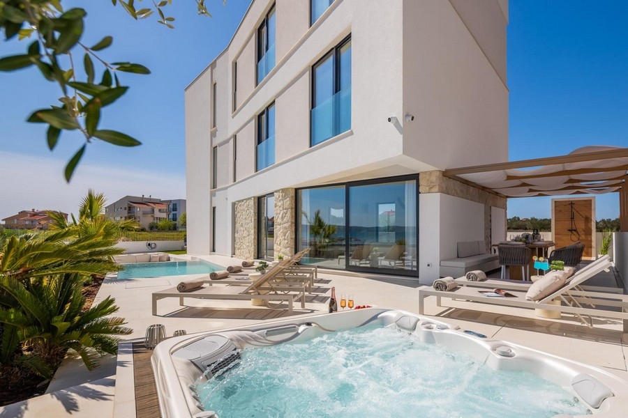Idromassaggio sulla terrazza con piscina e pergola dietro