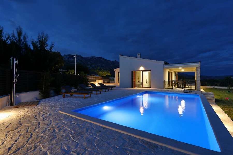 Piscina illuminata davanti alla casa all'ora blu