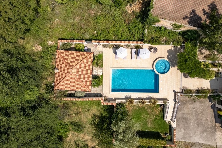 Vista aerea di tetto in tegole e piscina con ombrelloni