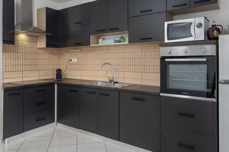 Cucina componibile dal design scuro con dotazioni moderne
