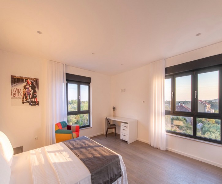Camera da letto con scrivania e finestre panoramiche