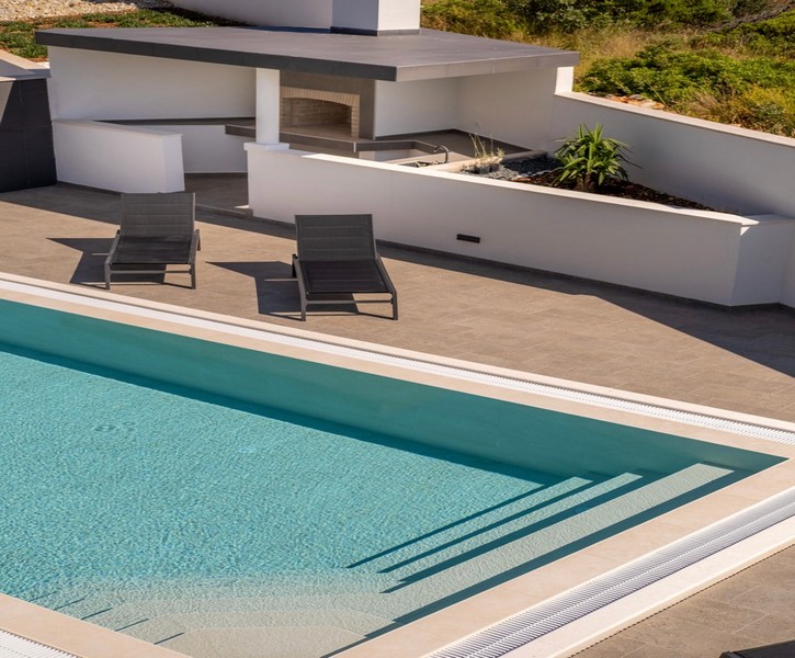 Area piscina con lettini e moderna cucina estiva