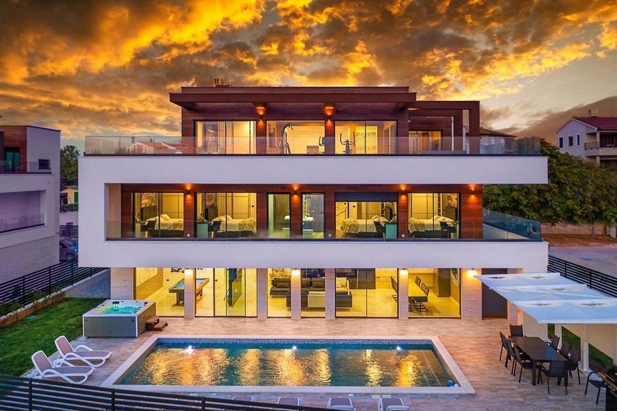 Villa illuminata con piscina e idromassaggio al tramonto
