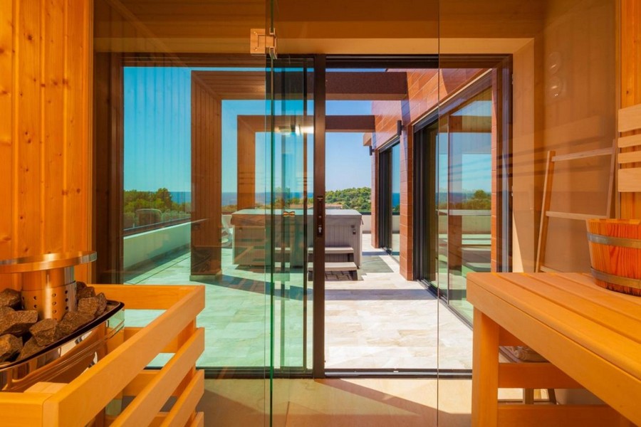Sauna con vetrata e accesso alla terrazza con vista mare