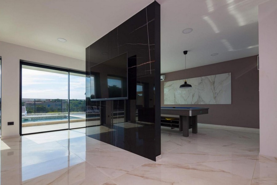 Zona giorno aperta con elementi moderni e vista sulla piscina
