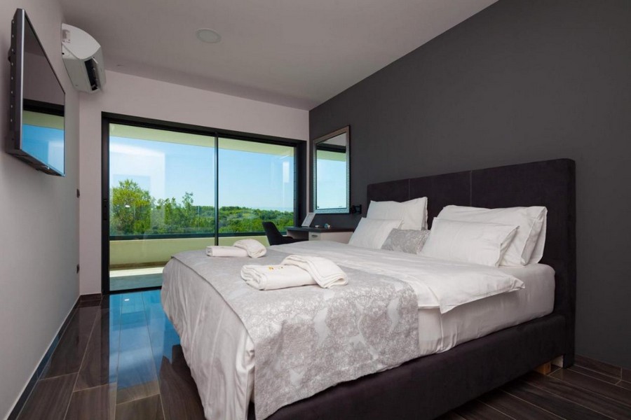 Elegante camera da letto con letto matrimoniale e vista sul verde