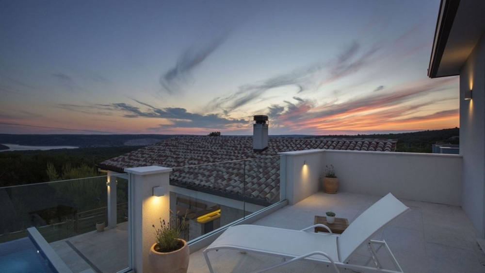 Terrazza della villa con lettini e vista panoramica al tramonto