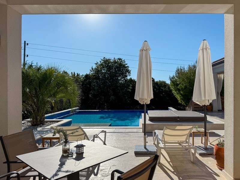 Terrazza coperta con zona salotto e vista sulla piscina
