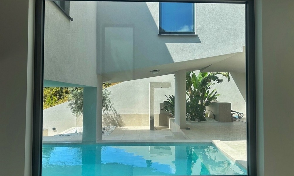 Vista dall'interno sulla piscina e sul patio