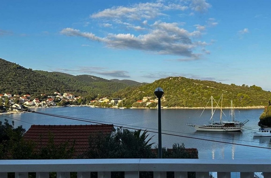 Vista dal balcone sulla baia con barca a vela